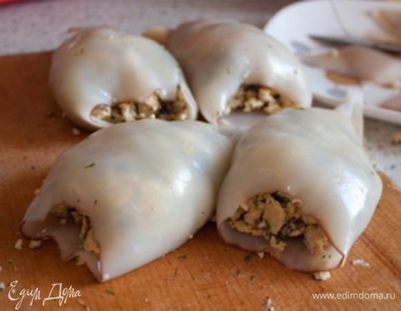 Полученным фаршем наполняем тушки кальмаров. Закрепляем зубочисткой и укладываем в форму для запекания. Сверху можно также присыпать сыром для аппетитной корочки.