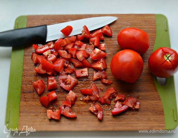 Помидоры необходимо поместить в миску, надрезать каждый томат крест-накрест у основания плодоножки, обдать кипятком, дать постоять 1 минуту и затем поместить под холодную воду. При помощи тонкого ножа снять кожицу с томатов и нарезать кубиками. После чего добавить помидоры и жарить до испарения сока (около 10 мин). Посолить, поперчить, приправить сухими травами, тщательно перемешать и снять с огня. 