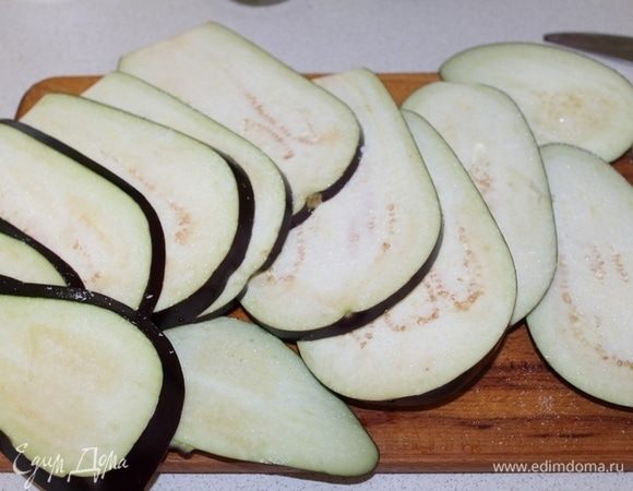 Баклажаны разрезать на дольки, обильно посолить и оставить на 15 минут.