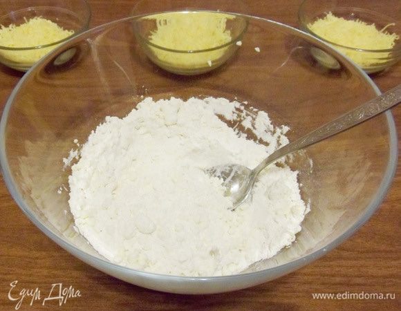 Для приготовления теста в миску положить муку, щепотку соли и натереть на крупной терке сливочное масло.