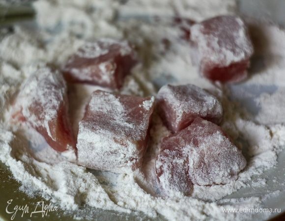 Некрупными квадратными кусочками нарезать свинину и обвалять в слегка подсоленной муке.