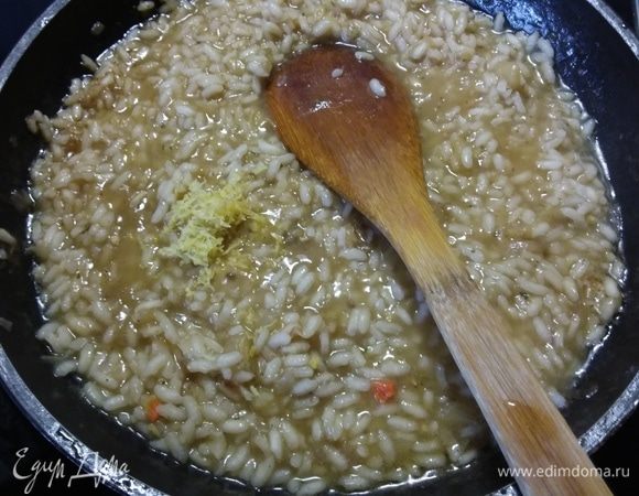 Когда рис будет готов (процесс продолжается примерно около 20 минут, рис не должен развариться и превратиться в кашу, а иметь в серединке плотноватую консистенцию), добавить цедру половины лимона и 2 ст. л. лимонного сока. Посолить (с учетом пармезана) и поперчить. 