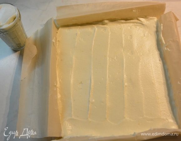 Выложить массу в форму и разровнять. Я смастерила форму из бумаги для выпечки: просто подняла бортики по бокам. Часть массы оставить для смазки слоев, где-то чуть меньше стакана.