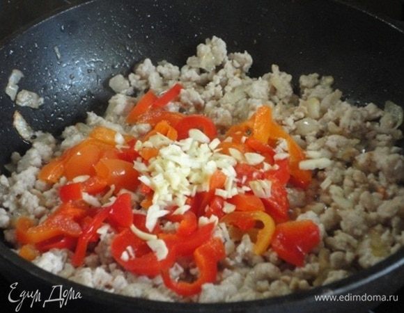 Добавьте нарезанный болгарский перец и измельченный чеснок. Обжаривайте еще 3-4 минуты. В конце приправьте паприкой, перемешайте и снимите с огня.