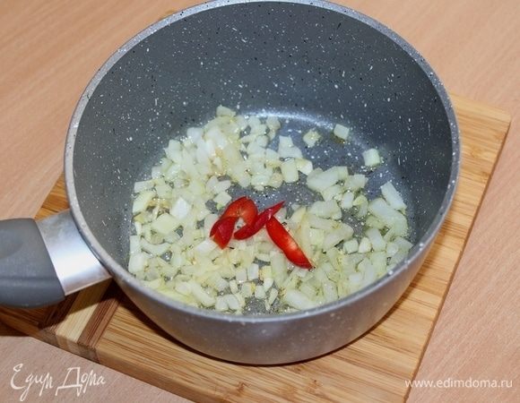 В сотейнике разогреть 2 ст. л. оливкового масла, слегка подрумянить лук и перец чили.