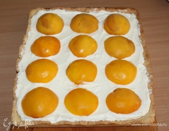 Выложить на крем половинки персиков.  Приготовить желе как указано на упаковке. Покрыть им персики.