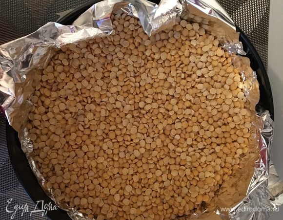 Поверх теста кладем фольгу и насыпаем сверху пригруз. Ставим в предварительно разогретую до 180°С духовку и выпекаем в течение 10 минут. Вынимаем, убираем фольгу с пригрузом, накалываем дно вилкой и возвращаем в духовку еще на 15 минут.
Вынимаем из духовки и оставляем остужаться.