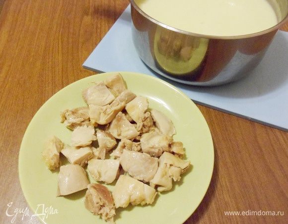 Отварное филе нарезать кусочками и вернуть в суп.