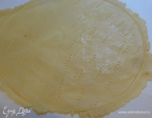 Корж раскатываем прямо на пергаменте. Вырезаем нужный диаметр, у меня — 24 см, накалываем вилкой.