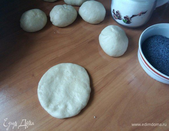 Смазать немного стол растительным маслом. Муку я не использую. Накатать шариков примерно с куриное яйцо. Хотя размер на Ваше усмотрение. Взять 1 шарик. Будем делать бантик. Руками расплющить в лепешку.