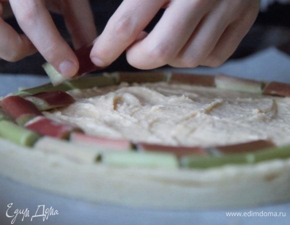 Тесто должно немного остыть, после чего выкладываем начинку, распределяем ровным слоем и сверху выкладываем ревень.