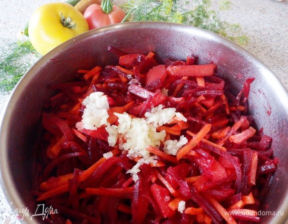 Выдавить в овощную смесь зубчики чеснока. Перемешать и обжаривать около 1 минуты.