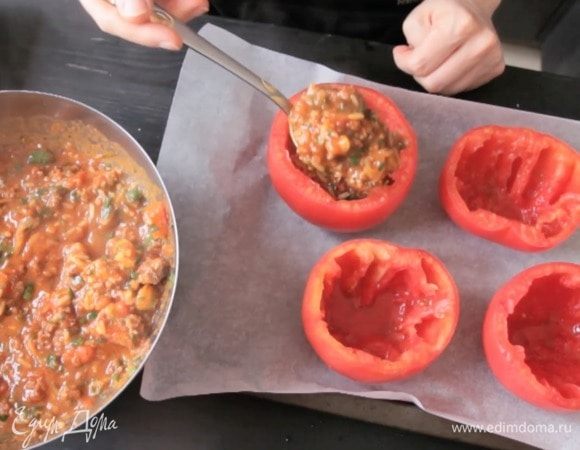 Смешать начинку с зеленью и фаршировать томаты.