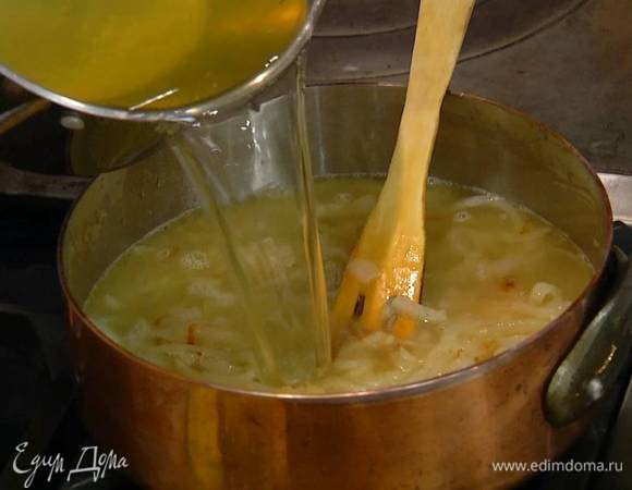 Добавить лавровые листья, гвоздику и душистый перец, все перемешать, затем влить горячий бульон, так чтобы лук был полностью покрыт, и уварить жидкость почти вполовину.