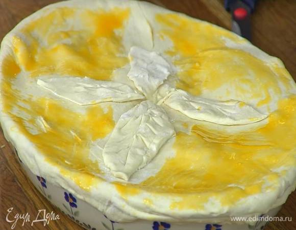 Из оставшегося теста вырезать украшения в виде листочков или косичек и поместить сверху на пирог, в центре сделать надрез и смазать все желтком, перемешанным с солью.