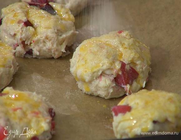 В яичный желток влить оставшееся молоко, посолить, перемешать и смазать булочки, затем посыпать их коричневым сахаром.