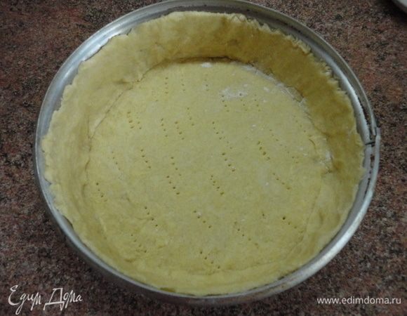 Выложить в разъемную форму (диаметр 23 см), формируя бортики. Наколоть вилкой и поставить в холодильник. Включить духовку для разогрева до 200°С.