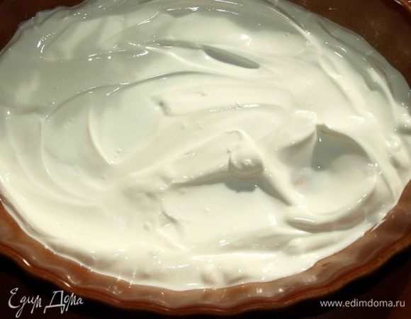 На дно керамической формы для запекания выкладываем сметану.


