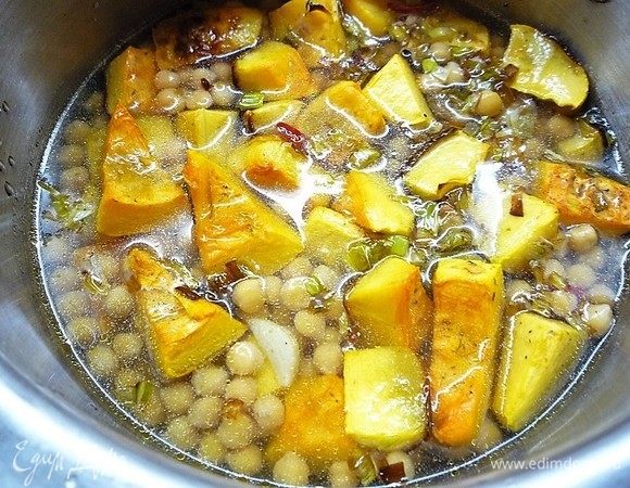 Вливаем горячий бульон, можно просто воду, чтобы она покрывала тыкву и нут. Все хорошо перемешиваем, накрываем крышкой и варим в течение 5-7 минут. 