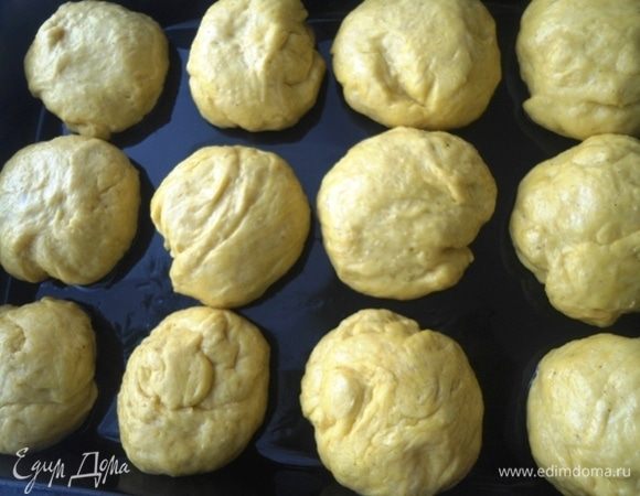 Разделить тесто на 12 булочек. Выложить их на расстоянии в смазанную растительным маслом форму. Оставить на расстойку на 20 минут.