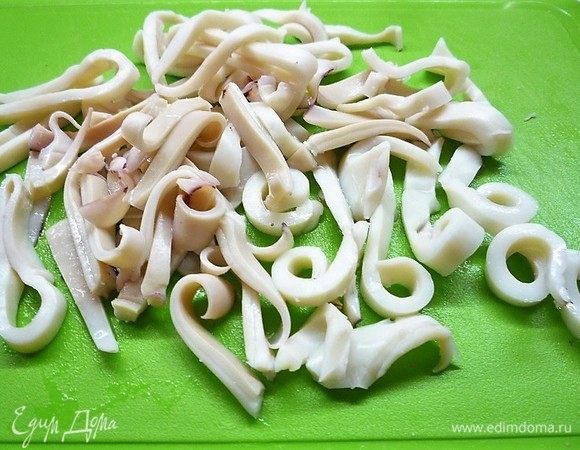 Кальмары очищаем, опускаем в кипящую подсоленную воду и отвариваем в течение 5 минут. Остужаем и нарезаем полосками.