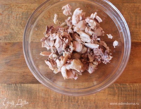 Отварные куриные бедра порезать мелкими кусочками или руками разобрать на волокна.