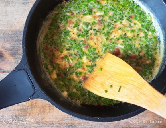 К отрубям влить взбитые с зеленым луком яйца и тут же начать интенсивно перемешивать деревянной лопаткой по часовой стрелке. Время — 2-3 минуты, не больше, иначе скрамбл потеряет сочность.