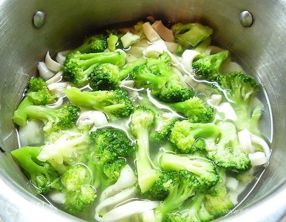 Добавляем к кальмарам брокколи, перемешиваем и даем закипеть.