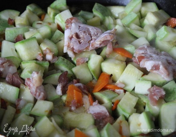 К обжаренным овощам добавить кабачки и мелко порезанный бекон. Обжарить.