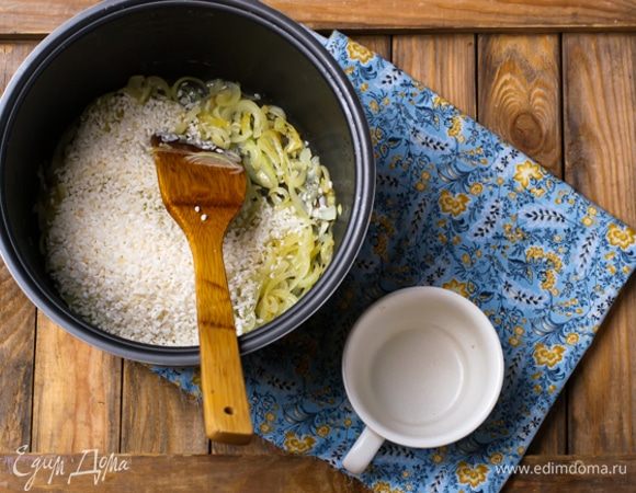 Одну луковицу мелко порубить. Нагреть в мультиварке 1 ст. л. растительного масла и обжарить порубленные грибы с луком до румяности, добавив чеснок, пропущенный через пресс. Вынуть в миску, приправить солью и перцем и немного лимонным соком. Нагреть в мультиварке еще 1 ст. л. масла и спассеровать до прозрачности остальной лук, порезанный полукольцами. Всыпать промытый рис, посолить, влить 400 мл. кипятка и готовить под крышкой 10 минут.