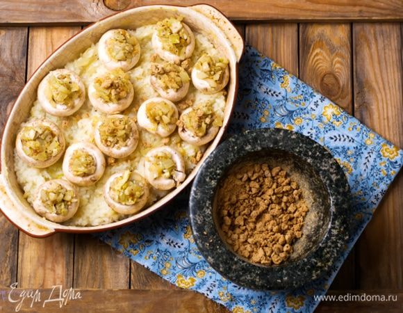 Смазать керамическую или стеклянную форму для запекания оставшимся растительным маслом и выложить рис ровным слоем. На рис положить шляпки шампиньонов и наполнить их жареным с грибами луком. Посыпать раскрошенными хрустящими бородинскими отрубями «Лито». Запекать 15 минут в духовке, нагретой до 200°С.
