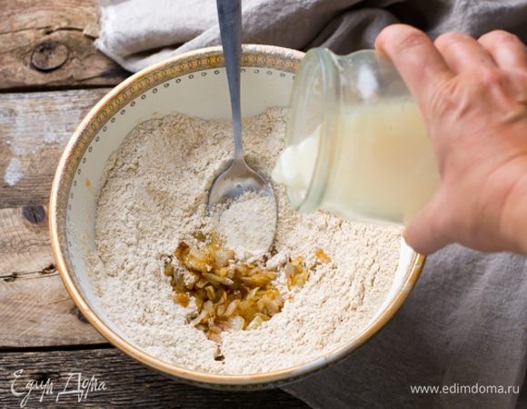В теплой воде развести мед, всыпать сухие дрожжи и дать им набухнуть. К мучной смеси добавить лук и порциями влить воду с дрожжами, замешивая эластичное тесто. 
