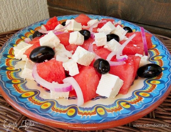 В плоский салатник или просто на тарелку выкладываем арбуз, фету, лук и маслины.