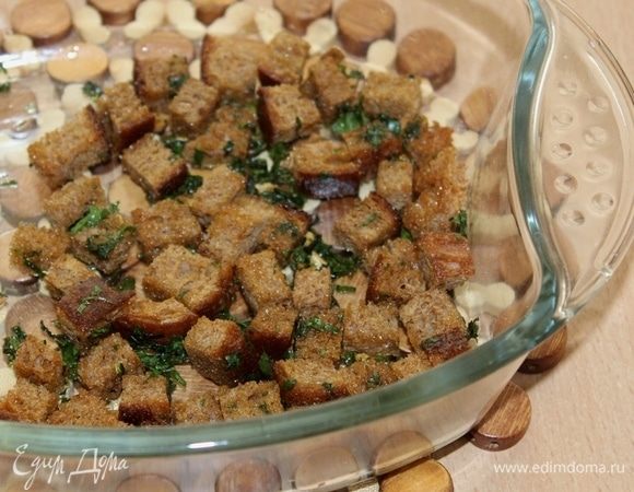 Хлеб нарезать кубиками, сбрызнуть оливковым маслом, посыпать измельченной петрушкой и чесноком и отправить в духовку на 20 минут при 180°С.