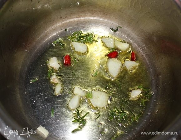 В кастрюлю с толстым дном наливаем оливкого масла 3 ст. ложки (остальное нам понадобится для украшения), высыпаем:
1. Листья тимьяна.
2. Порубленый чеснок.
3. Пеперончино (острый перец).
Пассеруем в течение 2-3 минут так, чтобы масло впитало весь аромат специй.