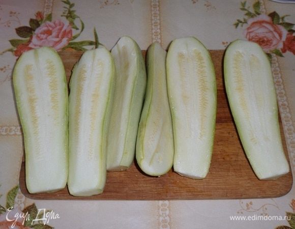 Подготавливаем продукты. Отвариваем до готовности рис (удобнее сварить 1 пакетик риса). Кабачки промываем водой. Разрезаем каждый кабачок вдоль на 2 части.
