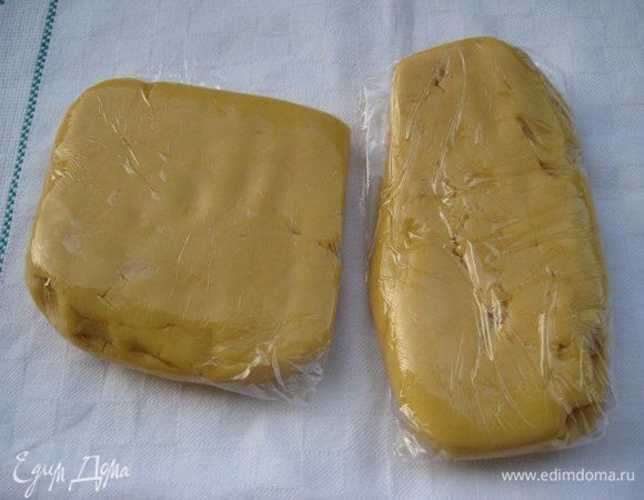 Добавить муку с разрыхлителем, замесить тесто. Готовое тесто собрать, разделить на две равные части, завернуть в пищевую пленку, убрать в морозильную камеру на полчаса.