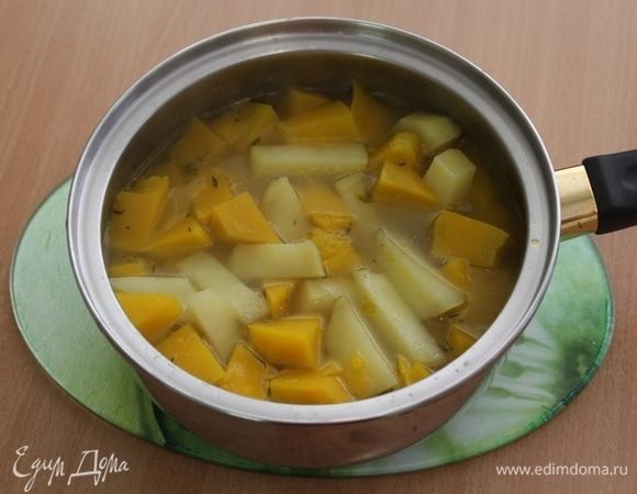 Переложить овощи в сотейник, залить овощным бульоном и потомить на огне минут 10.