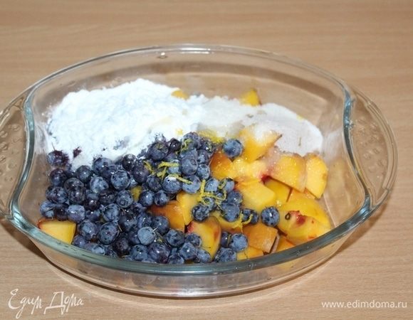 Персики порезать кусочками, добавить голубику, крахмал, корицу, сахар и лимонную цедру. Перемешать.