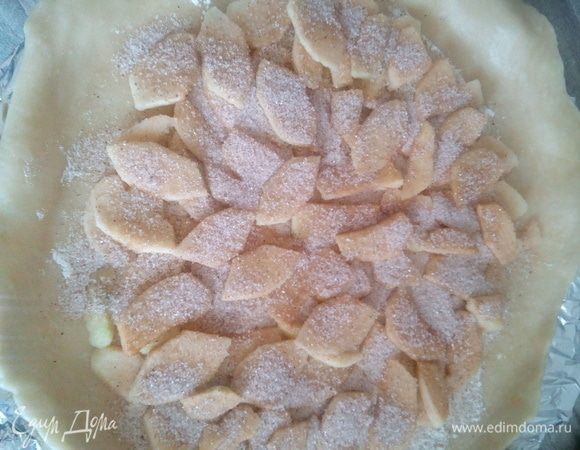 Тесто раскатать в круг толщиной примерно 0,5 см и выложить в форму или на противень. Я использовала форму для пиццы. На тесто выложить яблоки, не доходя до краев, и посыпать коричным сахаром.