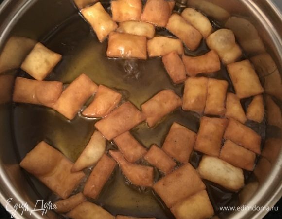 В кипящее масло отправляем горсть кусочков теста и начинаем мешать шумовкой, остальное тесто накрываем полотенцем. В процессе жарки нельзя отвлекаться, потому что тесто жарится очень быстро и может сгореть, если его передержать. 