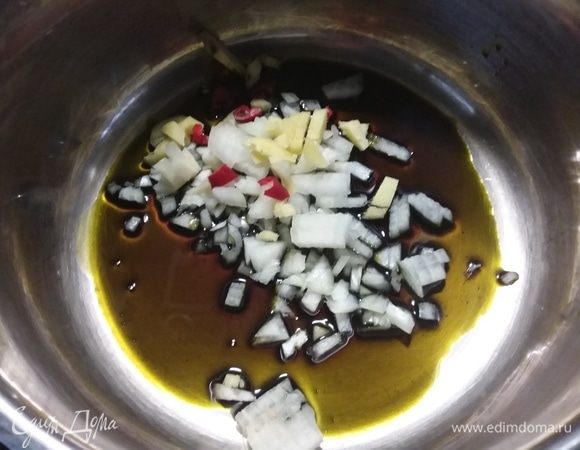 Разогреть в кастрюле тыквенное масло, пассеровать мелко нарезанный лук, имбирь и чили. 