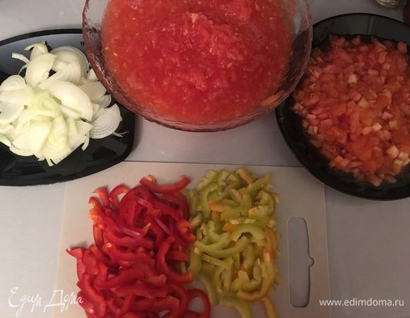 Лук порезать полукольцами. Перец разделить на 4 части и порезать полосками. Четыре помидора натереть на терке, а три других порезать небольшими кубиками.