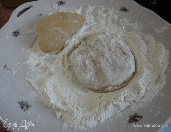 Разделите еще теплое тесто на 6 частей и держите его прямо в этой муке, используя ее при раскатке коржей. Пока раскатываете один кусочек, остальное тесто накройте полотенцем, чтобы оно не заветрилось. 