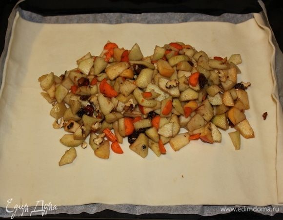 На противень выкладываем лист теста, сверху выкладываем на центр теста начинку и распределяем ее равномерно.
