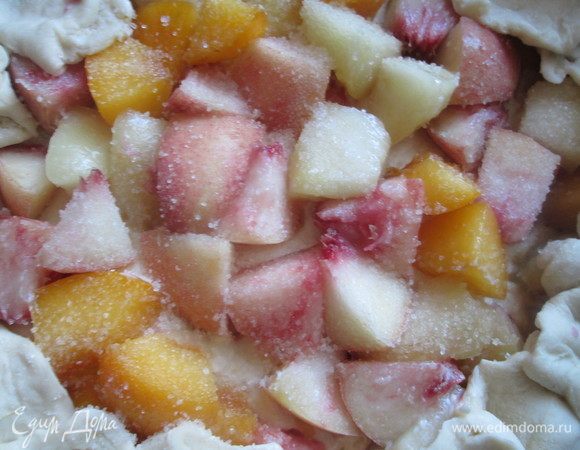 Фрукты посыпаем ванильным сахаром, а затем свободные края теста заворачиваем поверх фруктов. 