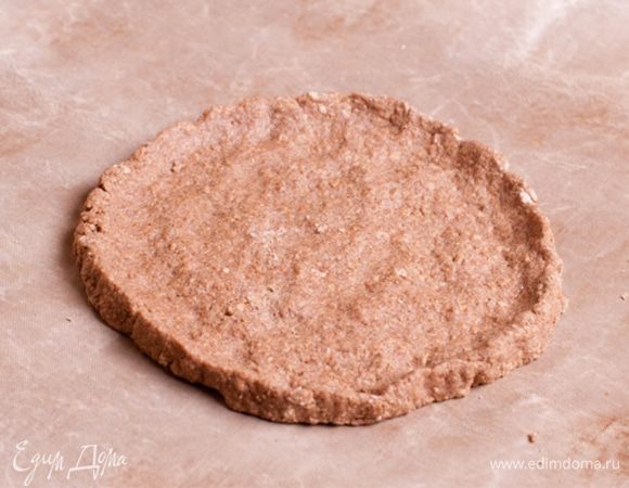 Полученное тесто разровнять на пергаменте в форме круга.