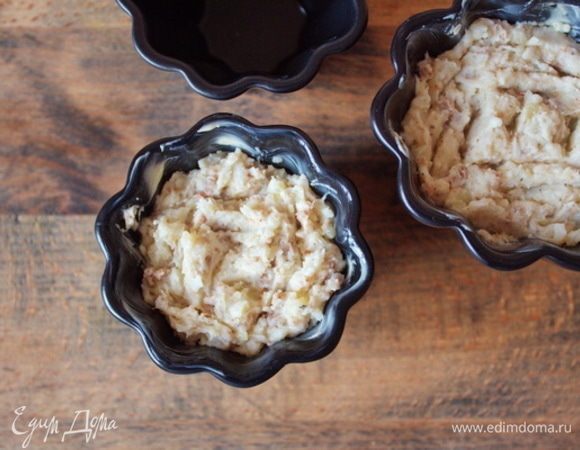 Порционные рамекины смазать сливочным маслом и заполнить картофельно-рыбным фаршем.
