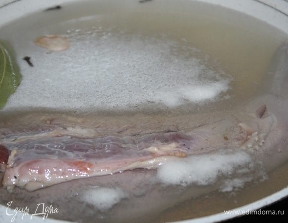 Язык залить холодной водой, добавить чеснок, гвоздику, лавровый лист. Варить 2 часа 50 минут на небольшом огне, пену снять.