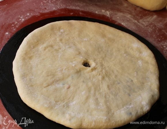 Переложите готовую лепешку на лист для выпечки швом вверх и на этом месте, аккуратно пальчиком сделайте дырочку. Пирог должен дышать, пар во время выпечки будет выходить из нее.